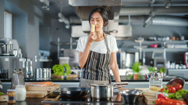 テレビクッキングショーキッチン:アジアの女性シェフが食材について話し、食べ物を調理することを教えます。オンラインビデオコース、教育テレビ番組。健康的な伝統的な料理のレシピの - commercial kitchen chef cooking food service occupation ストックフォトと画像