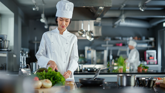 Modern Kitchen Restaurant: Portrait of Asian Female Chef, Crossing Arms and Looking at Camera Smiles. Professional Cooking Delicious and Authentic Food, Cuts Vegetables, Preparing Healthy Meal
