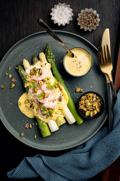green and white asparagus with prawns, pistachio nuts in a hollandaise sauce - hollandaise sauce imagens e fotografias de stock