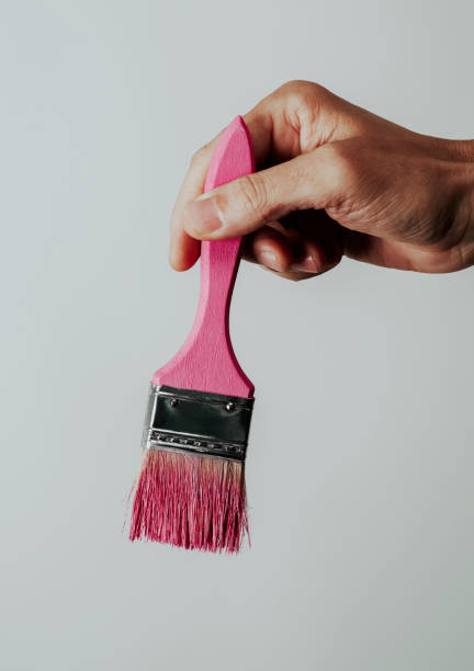 istock young man has a paintbrush with some pink paint 1391239422