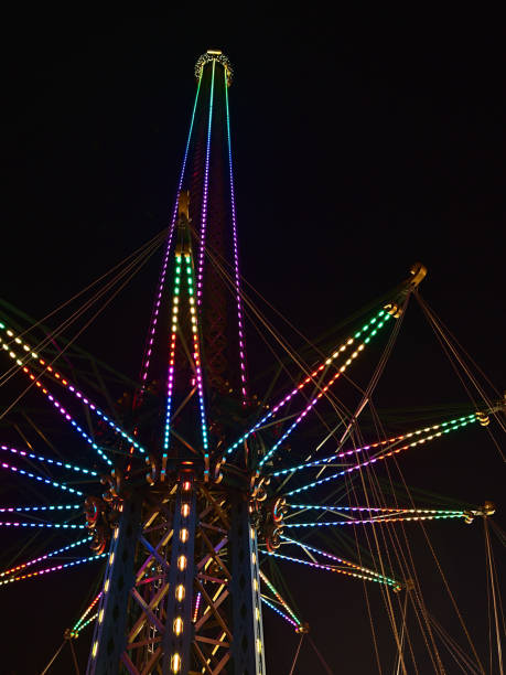 istock Low angle view of a drop tower with colorful, illuminated structure at night in amusement park Wurstelprater near Wiener Prater in city Vienna, Austria. Viewed from public ground. 1391243735