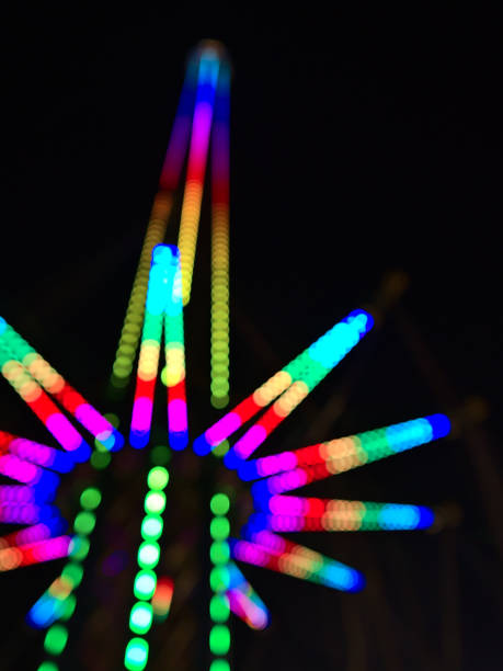 vue déconcentrée d’une grande tour de chute avec structure illuminée la nuit dans le parc d’attractions wurstelprater près de wiener prater dans la ville de vienne, en autriche. image floue. - wiener wurstelprater photos et images de collection