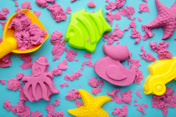 istock Pink kinetic sand for children, development and play at home with multi-colored sandbox molds 1391247144