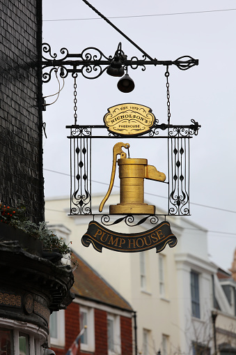 Brighton, United Kingdom - Feb 23, 2022: A gold colour sign outside The Pump House, a traditional pub in the heart of Brighton.