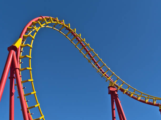 nahaufnahme der rot-gelb gefärbten schienen einer achterbahn im freizeitpark wurstelprater in wien, österreich an sonnigen frühlingstagen vom öffentlichen platz aus gesehen. - wiener wurstelprater stock-fotos und bilder