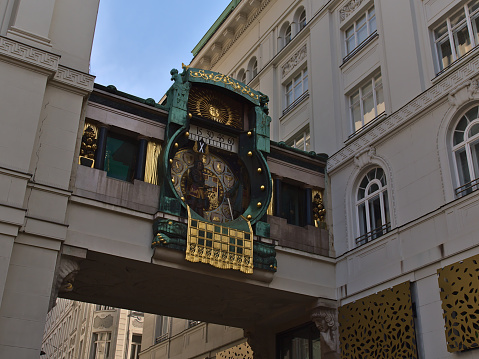 Beautiful view of the historic music clock Ankeruhr (Jugendstil, completed 1915) in the old downtown of Vienna, Austria located between old buildings.