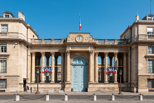 French flag winding and parisian facade architecture in Paris, France