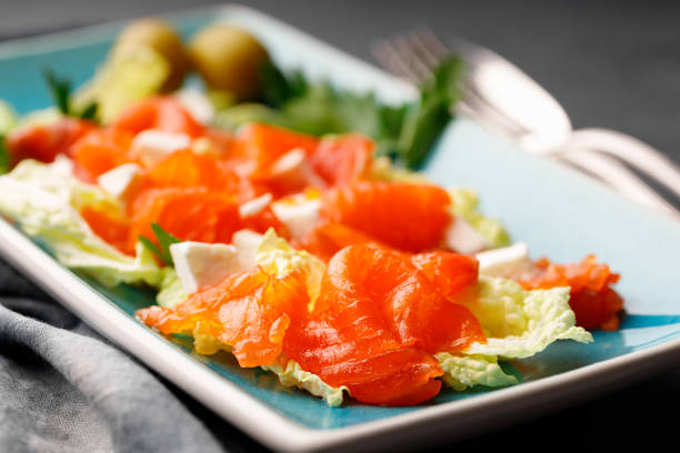 istock Gourmet food - salad from red salmon and herbs on a rectangular plate. 1391255492