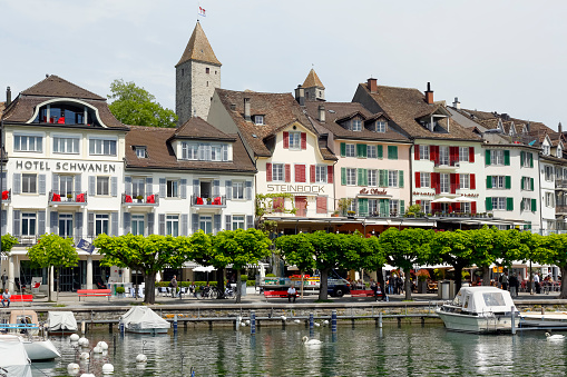 Rapperswil, Switzerland - May 10, 2016: Buildings, hotels and moored boats along promenade by the lakeside, all this shows the diversity of tourist attractions and recreational character of the city