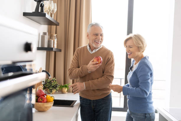istock Retirement senior couple laughing, standing on bright kitchen together 1391263562
