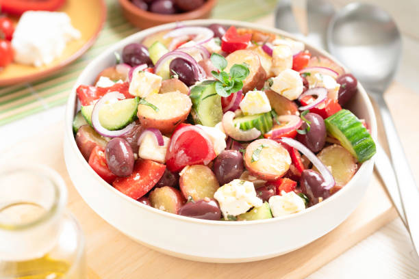 homemade greek potato salad fresh greek potato salad made with red potatoes, cucumber, bell peppers,cherry tomatoes, kalamata olives, onions, dressed in lemon juice, olive oil,oregano and topped with feta, perfect for a summer side dish bbq with mediterranean flavors Greek Salad stock pictures, royalty-free photos & images
