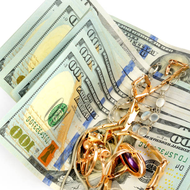istock US dollars and jewelry isolated on white background. 1391272199