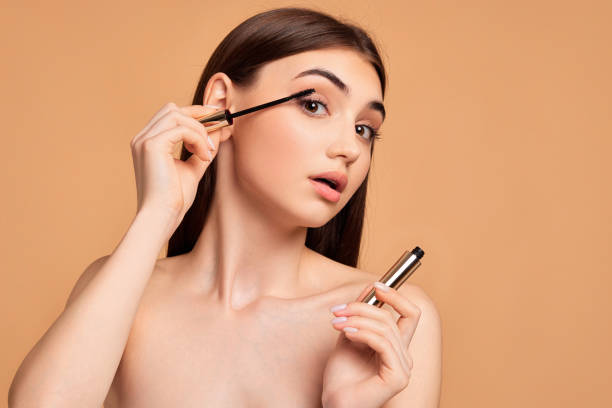 istock woman hold mascara isolated on beige background 1391272985