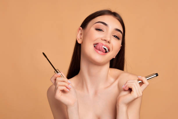 istock woman hold mascara isolated on beige background 1391273021