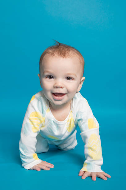 istock Happy Seven Month Old Baby Boy Crawling on Blue 1391273511