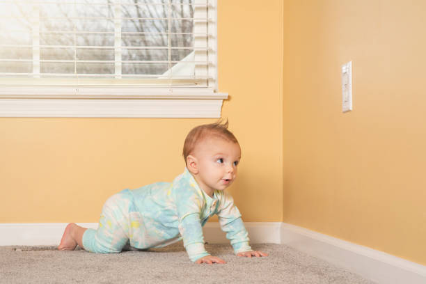 A 7 month old baby boy heading for the electric outlet he is curious about.
