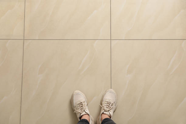 istock Woman standing on ceramic floor, top view. Space for text 1391274590