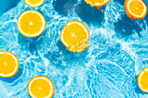 istock Creative summer composition made of sliced orange in transparent pool water. Refreshment concept. Healthy refreshing drink theme. Top view 1391275752