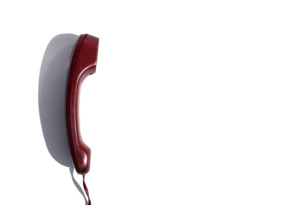 The handset from a wired telephone lies on a white background.