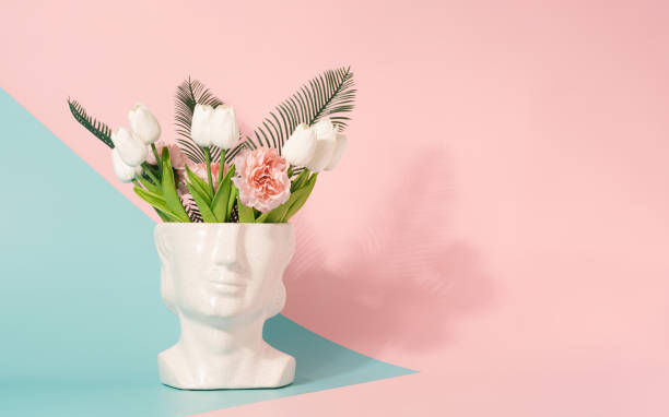 istock Y2K sculpture head with spring flowers on a pastel pink and blue background. 1391278563