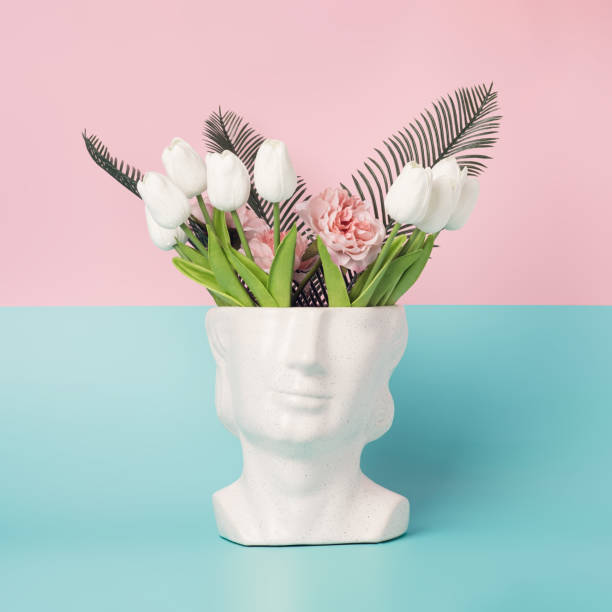 istock 80s statue head with spring flowers on a pastel pink and blue background. 1391278581