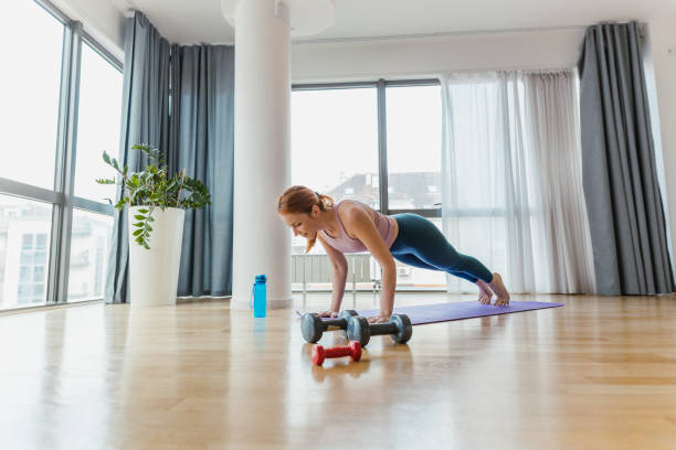 istock Young woman doing push-ups indoor 1391279338