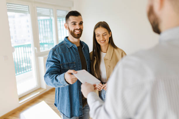 istock Estate agent giving to couple  a signed contract 1391281512