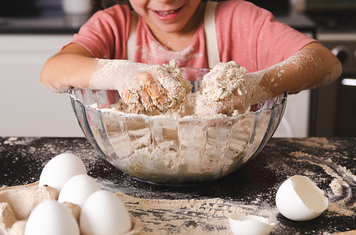 Little girl kneading in the kitchen.