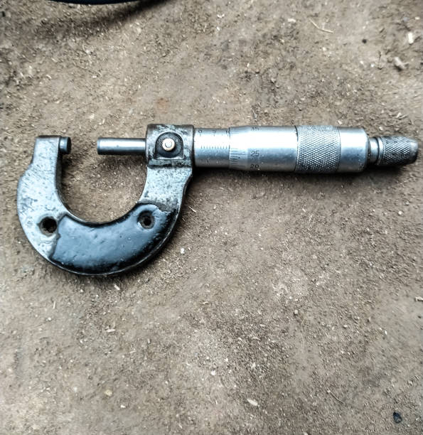 Screw gauge A screw gauge which is measuring tool placed on ground on blurry background. micrometer screw gauge stock pictures, royalty-free photos & images