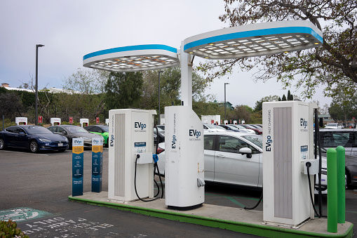 Carlsbad, CA, USA - Mar 25, 2022: An EVgo charging station is seen adjacent to a Tesla Superchargers hub in Carlsbad, California. EVgo is currently America's largest public EV fast charging network.