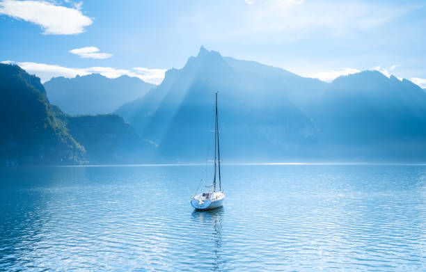 um iate no pano de fundo das montanhas na suíça. água calma e dia ensolarado. um lugar popular para viajar e relaxar. - lake geneva - fotografias e filmes do acervo