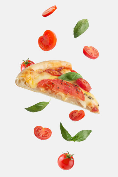 flying slice of margherita pizza with tomatoes and basil flying slice of margherita pizza with tomatoes and basil pizza stock pictures, royalty-free photos & images