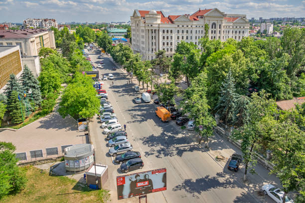 Pedestrians and cars move along a street in downtown Chisinau, Moldova on a sunny day.