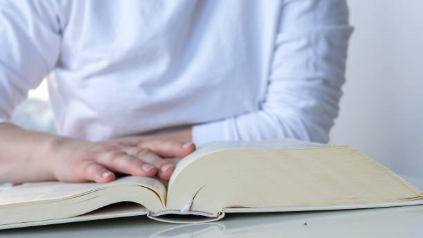 istock Woman reading the bible, pointing finger on text 1391298168