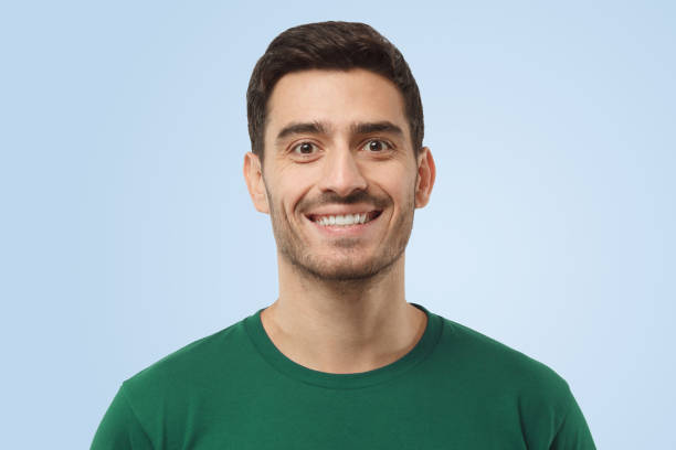 istock Attractive optimistic smiling handsome man in green t-shirt looking at camera 1391298356