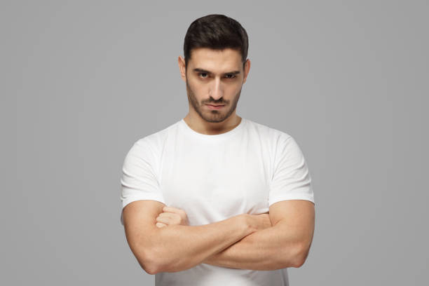 istock Tough guy standing with crossed arms isolated on gray background 1391298468