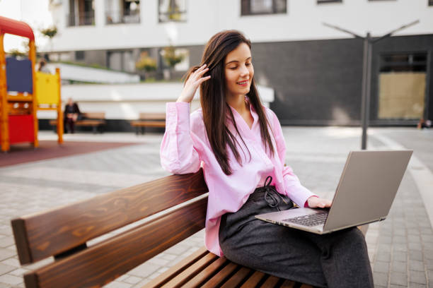 istock Businesswoman working on laptop while sitting on park bench 1391300936