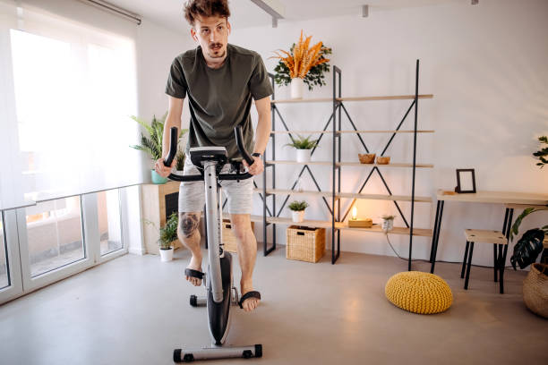 istock Young man exercising on a stationary bike 1391302047