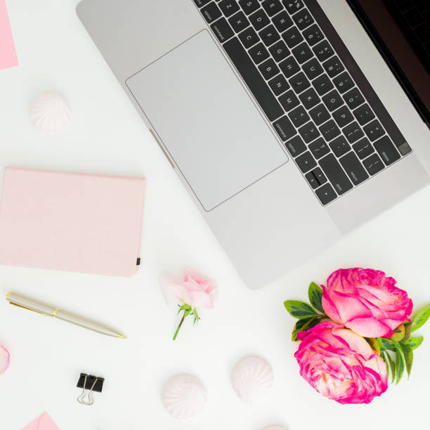 istock Laptop with roses, pen and diary on white background. Flat lay. Top view 1391303689