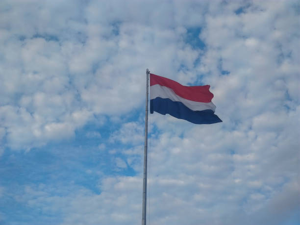 Paraguay flag on the flagpole in the blue sky.