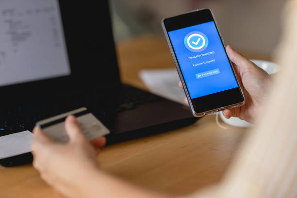 istock Young woman Paying Bills with mobile phone 1391305770