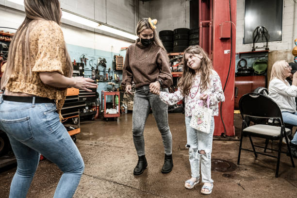 Latin women and girl dancing at the fiesta birthday party Mexican  women and girl dancing at the fiesta birthday party. They are wearing casual clothes. Interior of car and motorcycle repair shop with party decoration at night. happy birthday cousin images stock pictures, royalty-free photos & images