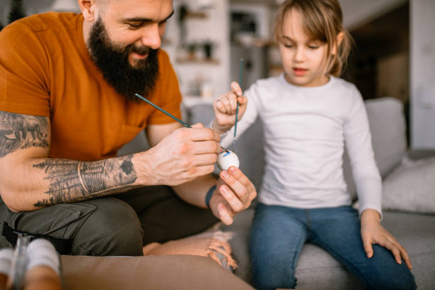 istock Father helping to his daughter painting eggs for easter holiday 1391312120