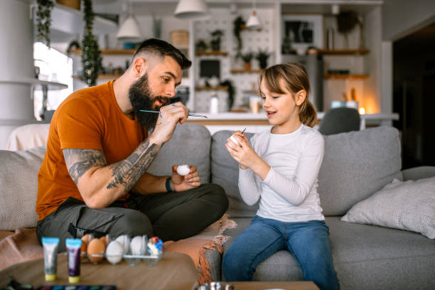 istock Father and daughter having fun decorating and painting easter eggs 1391312145