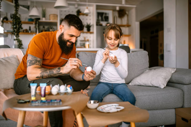 father and daughter having fun decorating and painting easter eggs - child easter egg home improvement easter imagens e fotografias de stock