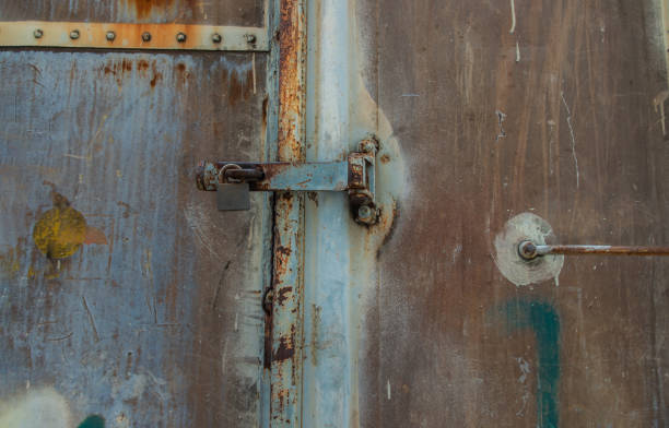 istock Metal locked padlock at Vintage railroad container doors gates. 1391315150