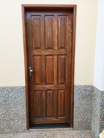 Old hotel with wooden door with the number 1