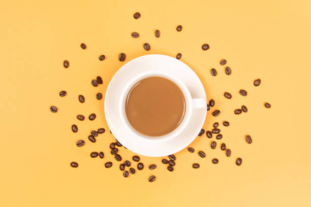 istock a cup of coffee with coffee beans on yellow background 1391324775