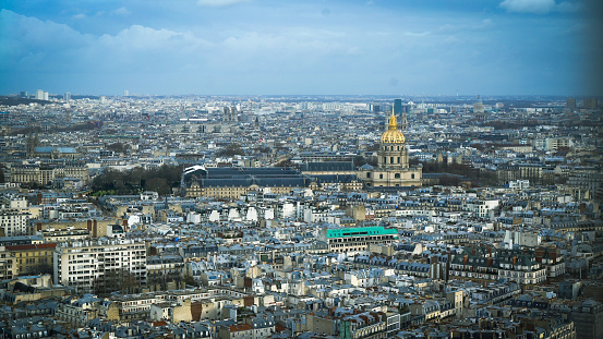 famous Eiffel Tower landmark and Paris roofs with clouds and sunshine, Paris France