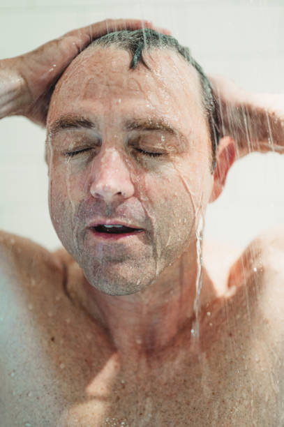 istock Middle age fit man getting wet, taking a shower or bathing 1391331776